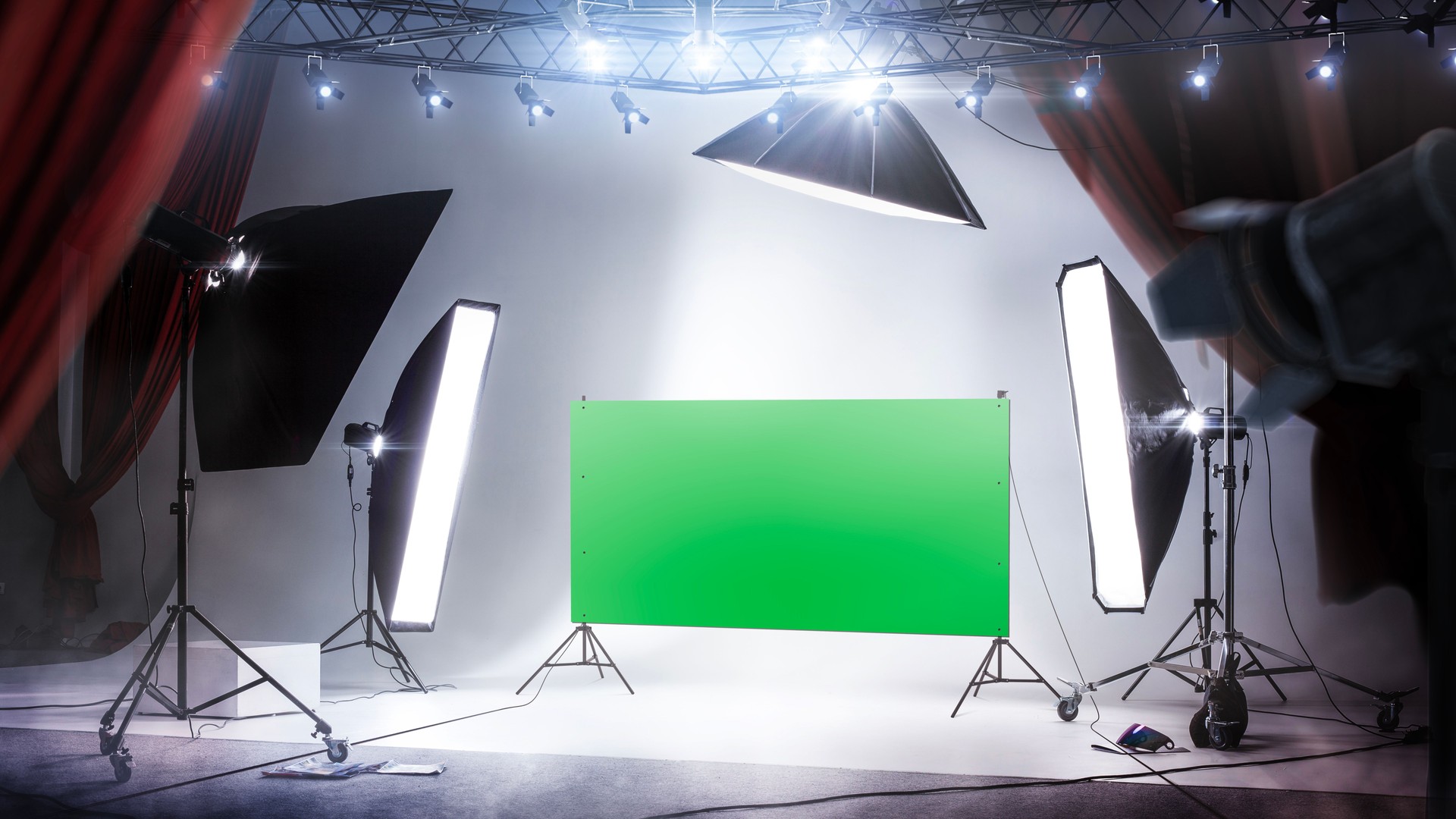 Photo studio background with green screen and backlight. professional lighting. Workspace interior with grey backdrop, backstage and lamps